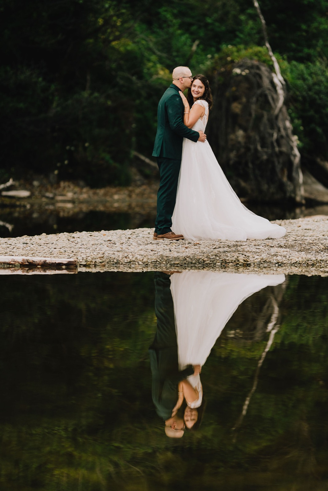 Adriana and Mitchell reflected in the wet sand at low tide with sea stacks on the horizon
