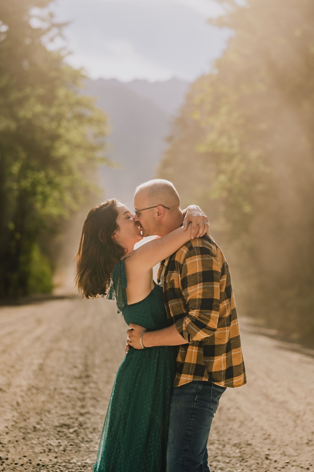 Adriana and Mitchell kissing on a fog covered forest road in Olympic National Park