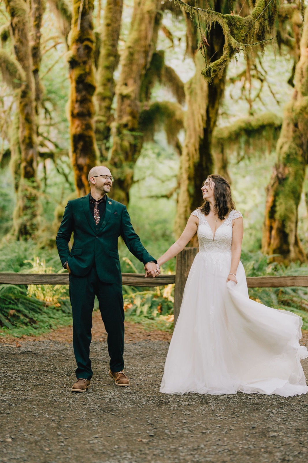 Bride and groom walking hand in hand through the old growth forest at their Olympic National Park elopement