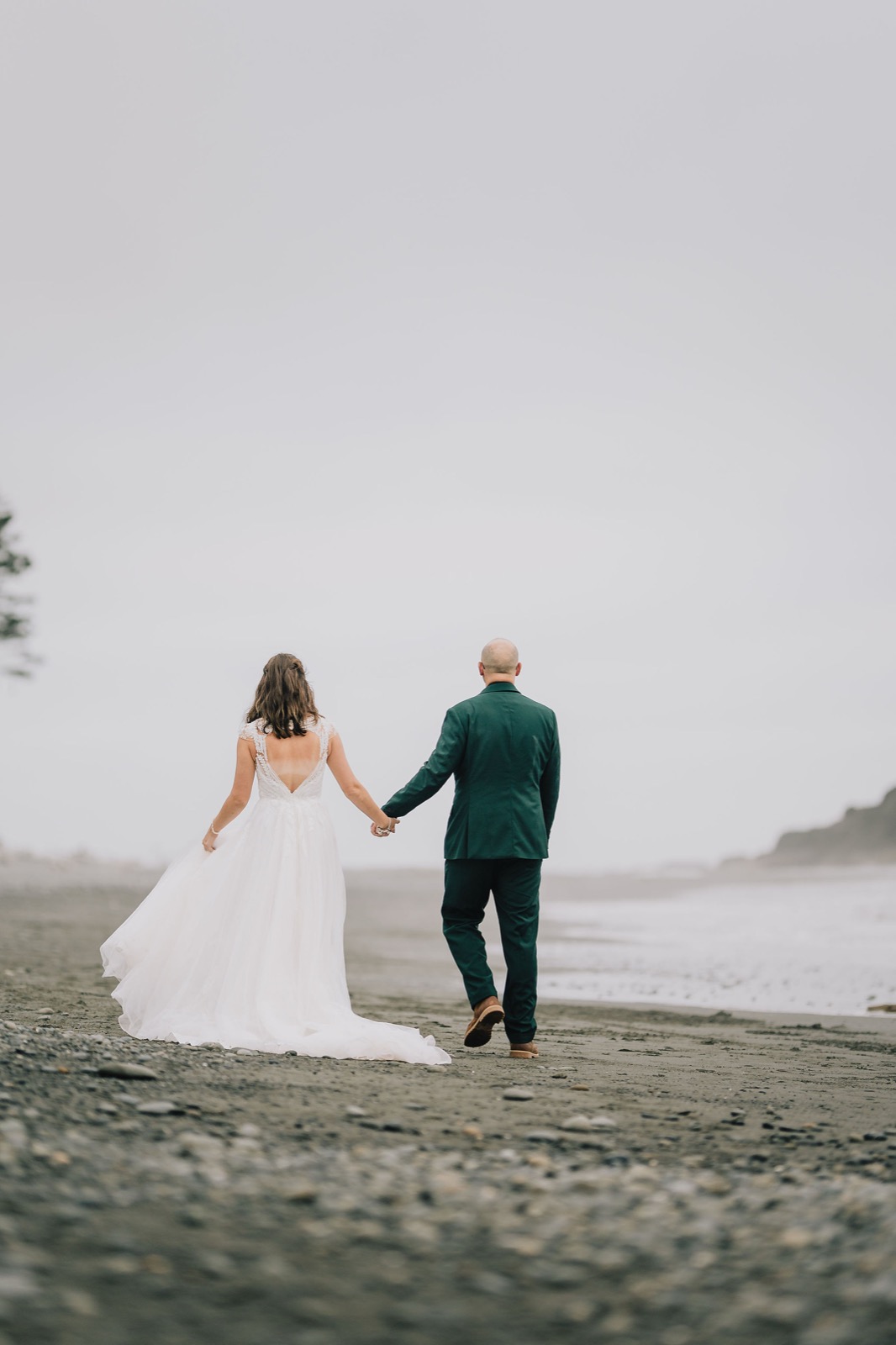 Couple walking toward the sea stacks on the foggy Washington shoreline