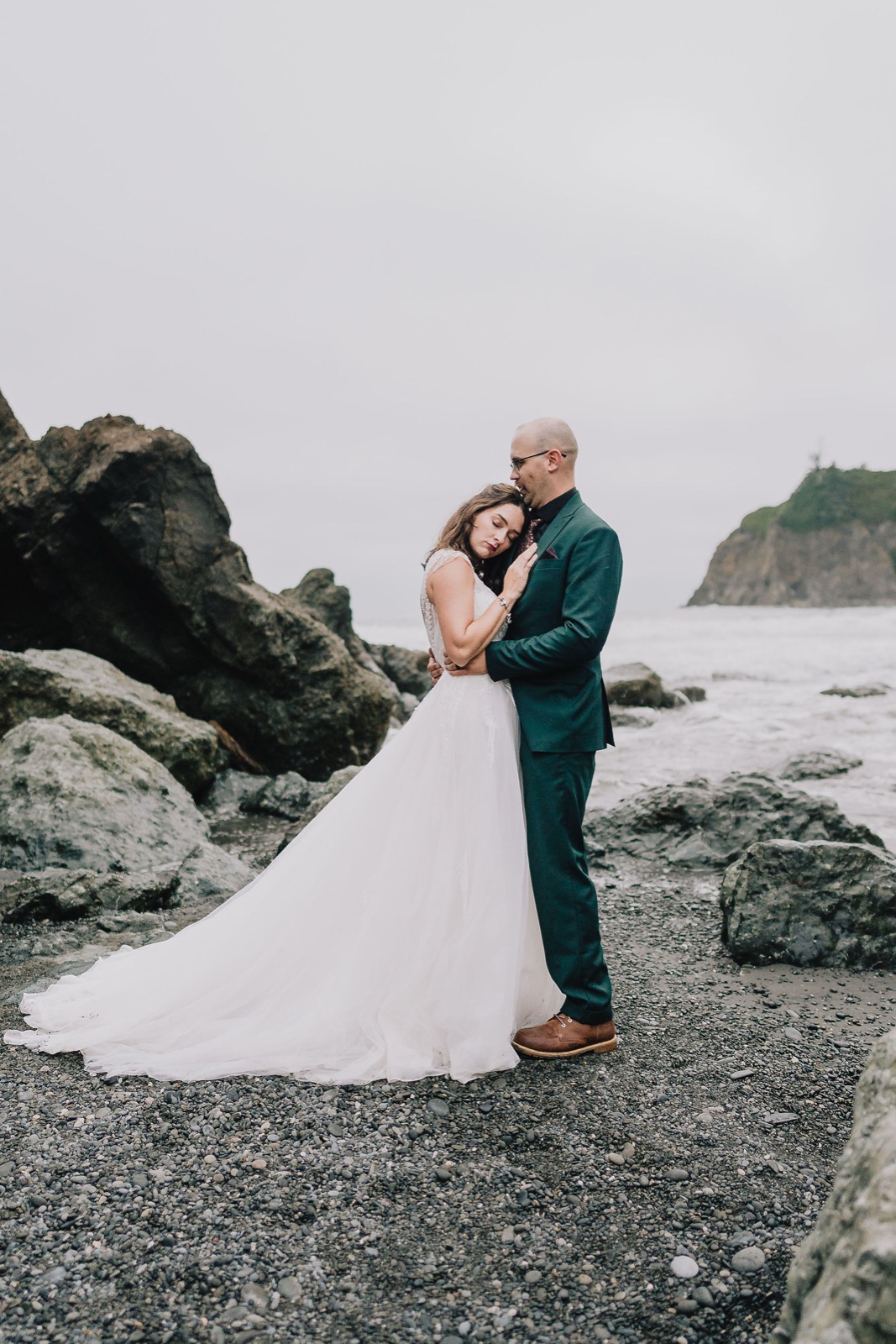 Couple framed inside a sea stack arch at Rialto Beach